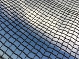 black mesh fence and the sky behind it
