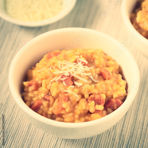 Fresh homemade carrot risotto made with pureed carrot and roasted carrot pieces, photographed with natural light (Selective Focus, Focus in the middle of the risotto) (Digitally Altered: Toned Image)