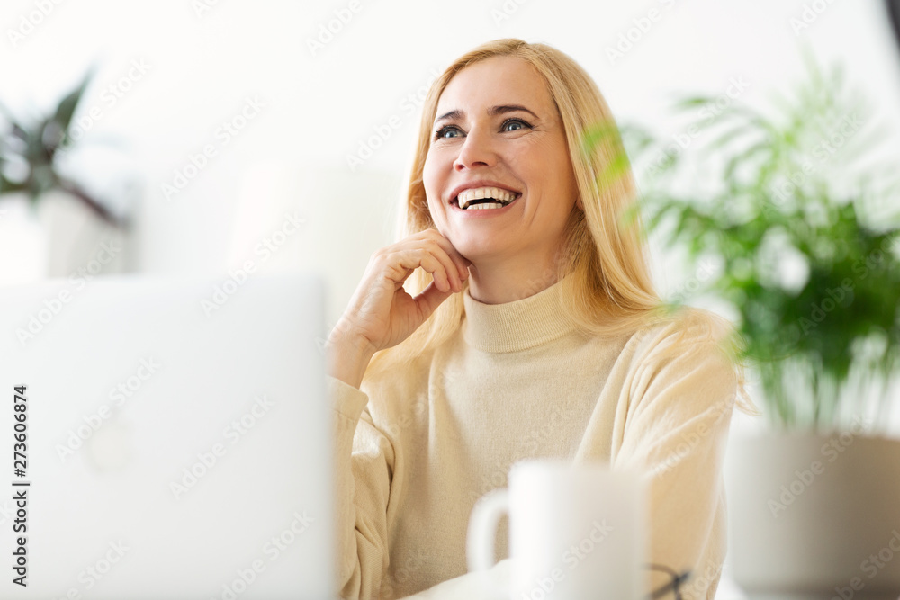 Happy Mature Woman Dreaming when Websurfing On Laptop Happy Mature Woman Dreaming when Websurfing On Laptop