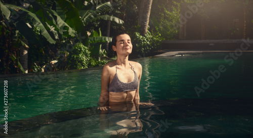 The girl in the infinity pool. Pool in the jungle. Holidays in Bali. The girl is tanning. Relax. © maksymbondarenko
