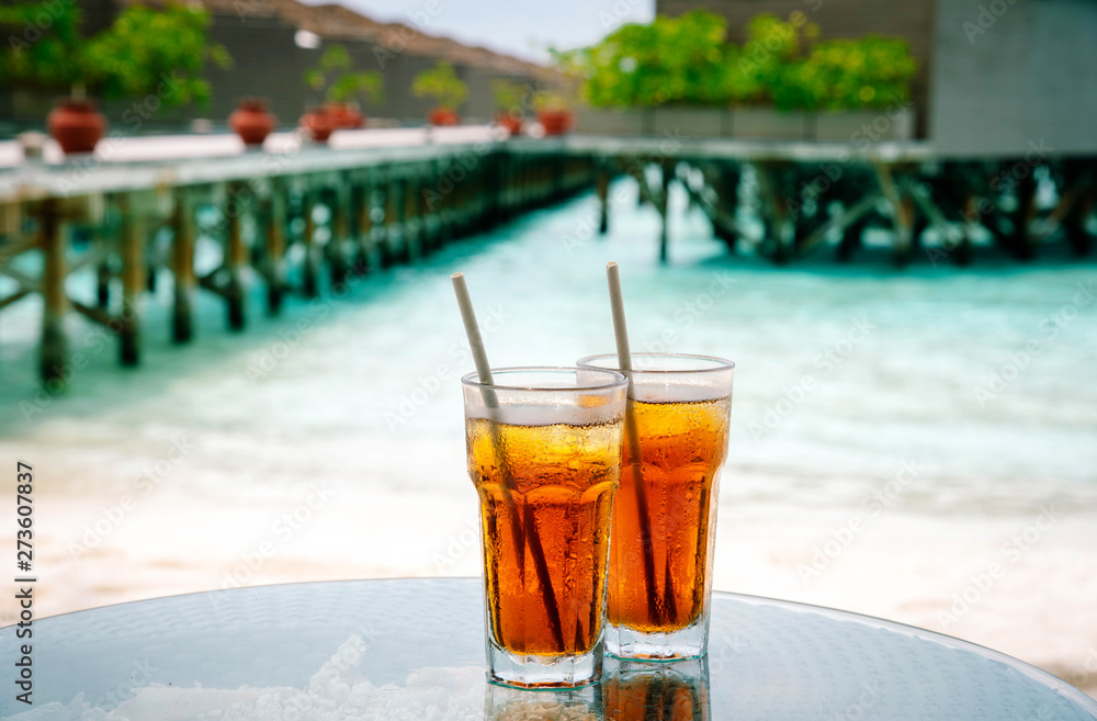 Iced tea against tropical Overwater Bungalow Resort, Maldives. Iced tea against tropical Overwater Bungalow Resort, Maldives.