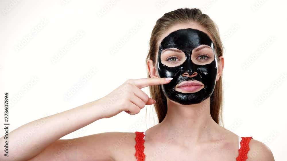 Girl with dried peel-off black mask on face Girl with dried peel-off black mask on face