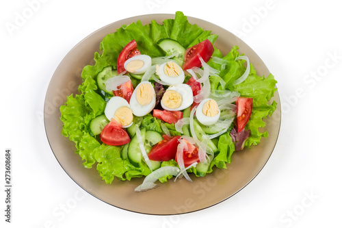 Vegetable salad with boiled quail eggs on the glass dish