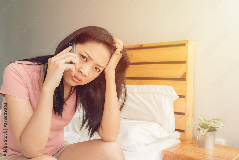 Upset woman is having a phone conversation on her bed. Upset woman is having a phone conversation on her bed.