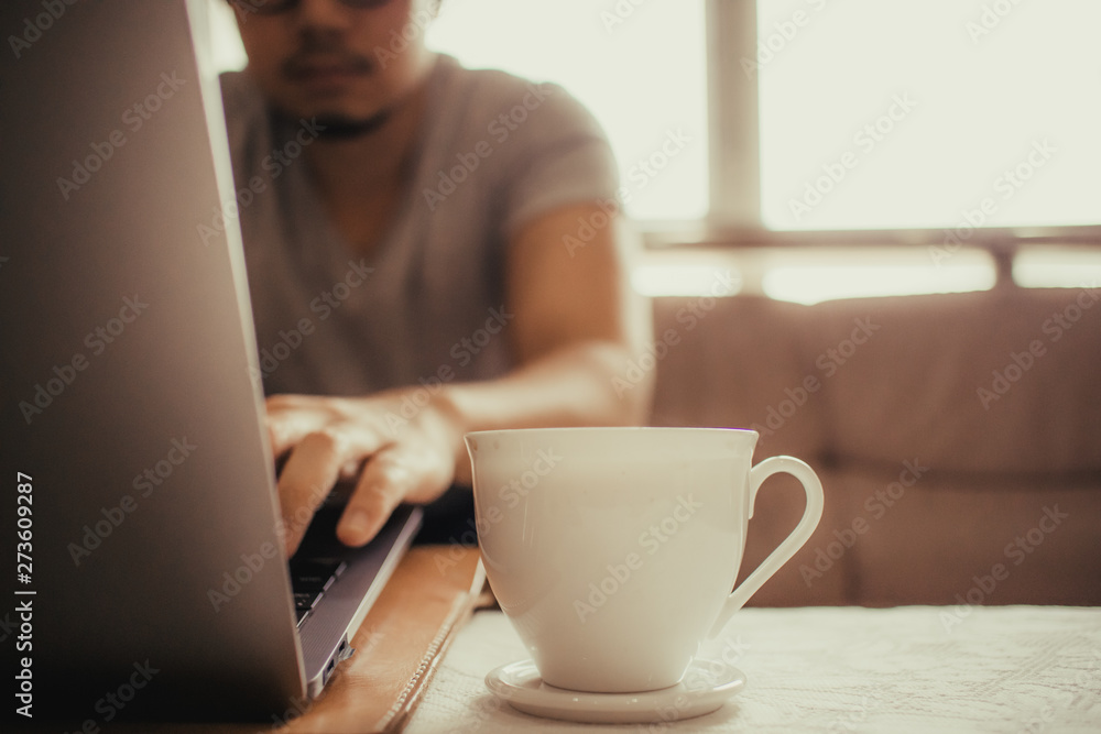 White cup of hot coffee on the table of a freelance man. White cup of hot coffee on the table of a freelance man.