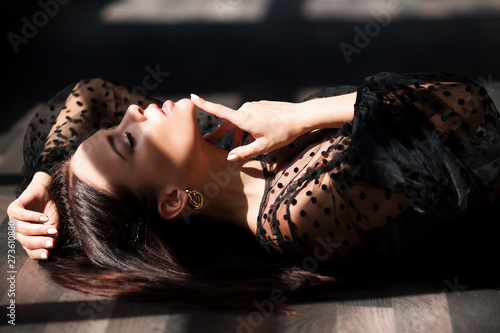 Fashion vogue style portrait of young stunning woman posing in sunset lightning with shadows in dark interior. Gorgeous glamorous brunette girl