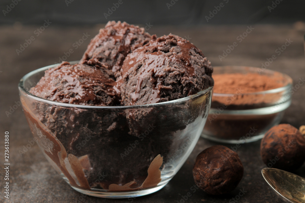 Chocolate ice cream with liquid chocolate with almonds and coffee beans on a dark background. Chocolate ice cream with liquid chocolate with almonds and coffee beans on a dark background.