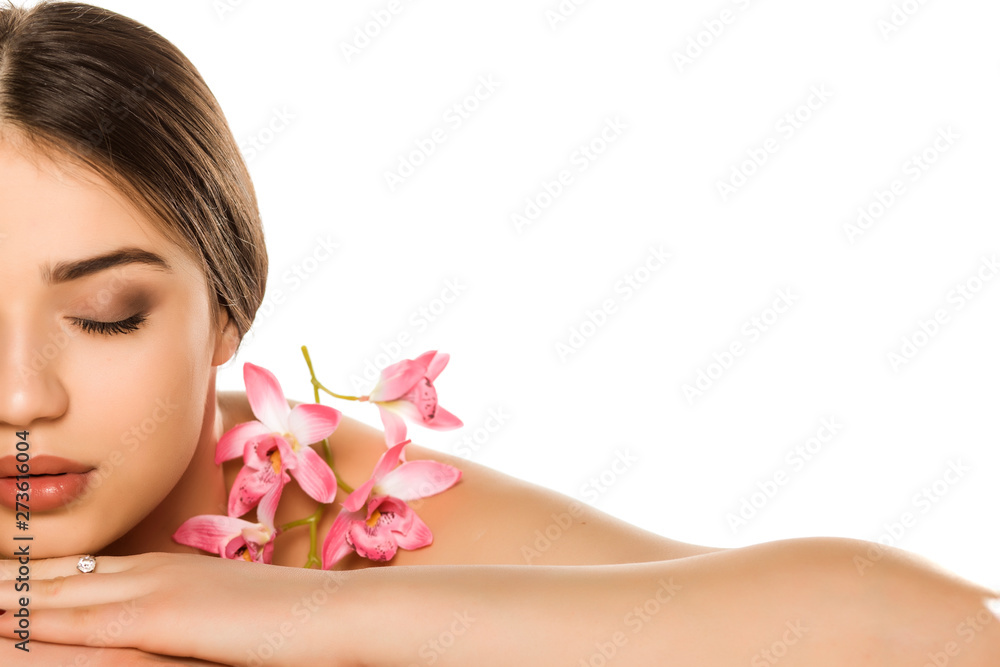 Half portrait of young woman with makeup posing with orchids on white background Half portrait of young woman with makeup posing with orchids on white background