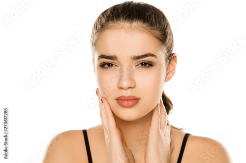 Young beautiful woman with paun in the jaw posing on white background photo