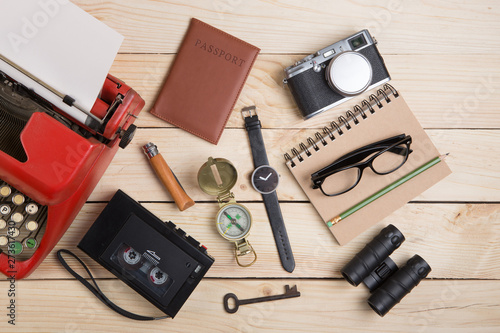 Writer or journalist workplace vintage red typewriter, photo camera, cassette recorder on the wooden desk