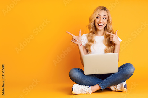 Excited Woman With Laptop Pointing On Copy Space