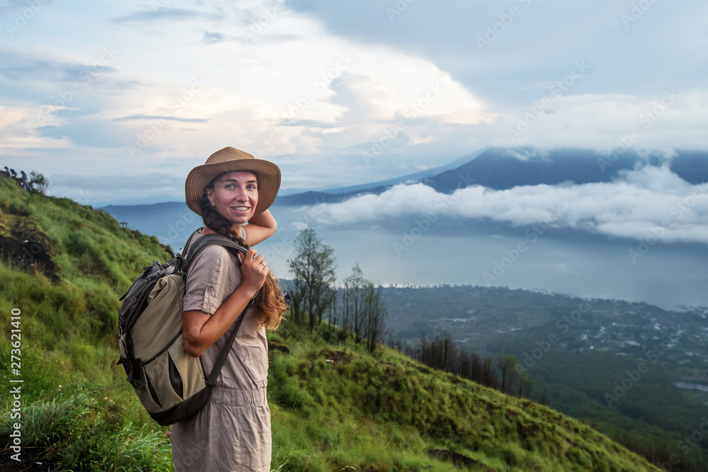 Woman enjoying sunrise from a top of mountain Batur, Bali, Indonesia.