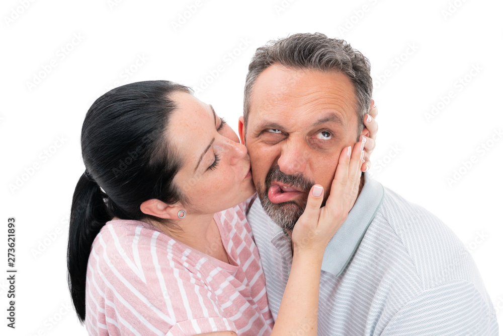 Woman kissing man with disgusted expression Woman kissing man with disgusted expression