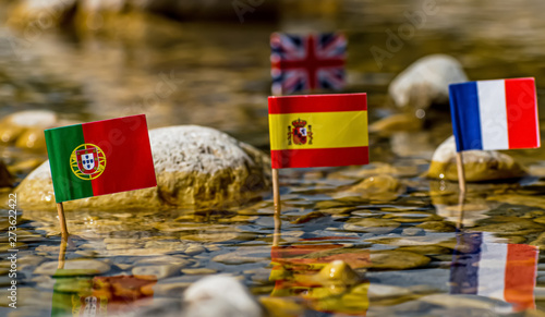 Fototapeta Naklejka Na Ścianę i Meble -  Portugal,Spain and France flags on foreground and uk in the background in river environment