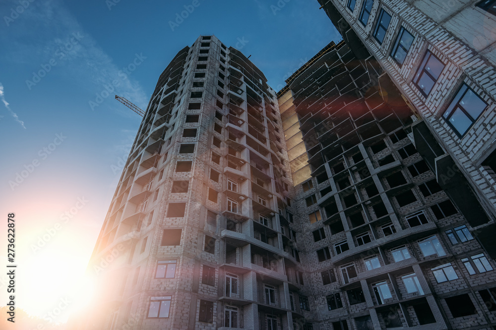 Fototapeta premium Construction site of new modern residential building at sunset sky background