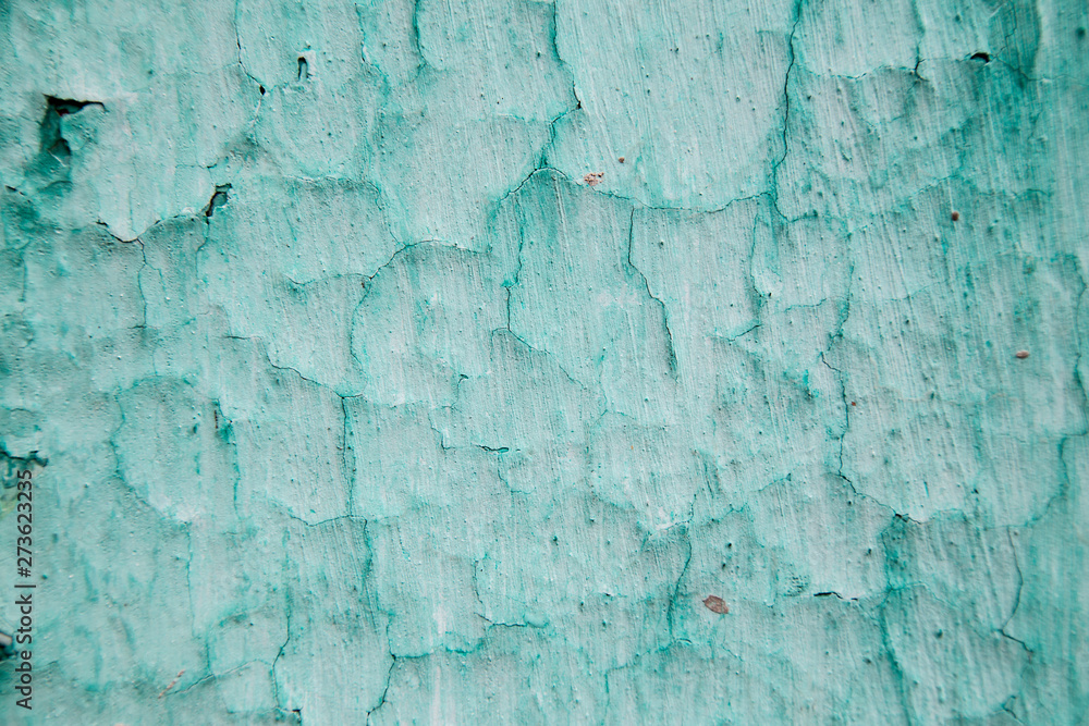 An old ragged plaster  green wall texture, cracked and old  for background,rough cement wall