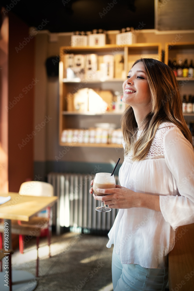 Happy beautiful young woman resting in coffee shop