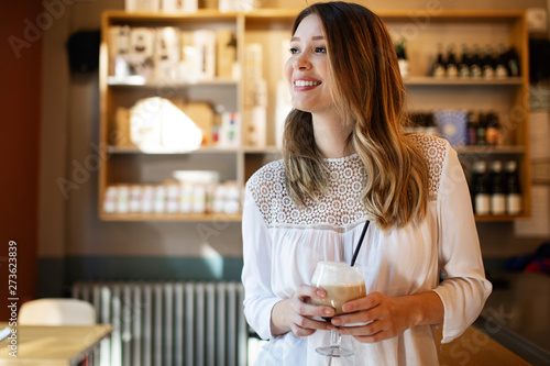 Beautiful smiling woman drinking coffee at cafe, home, at work