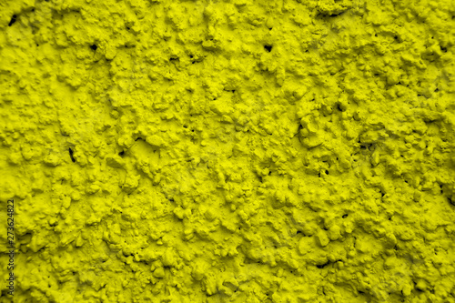 An old ragged plaster yellow wall texture, cracked and old for background,rough cement wall
