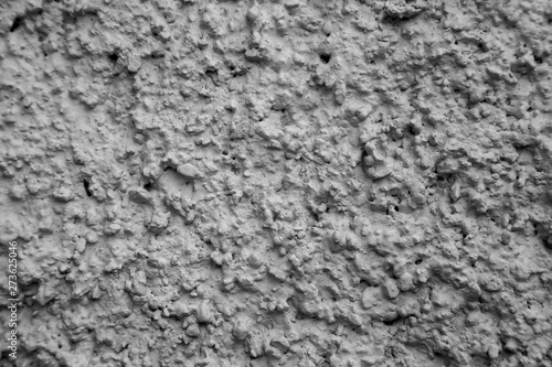 An old ragged grey plaster wall texture, cracked and old for background,rough cement wall