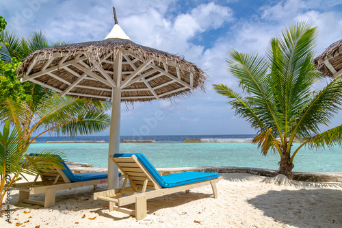 ein schöner Strand mit Sonnenschirm, Palmen und Liegen © Robert Leßmann