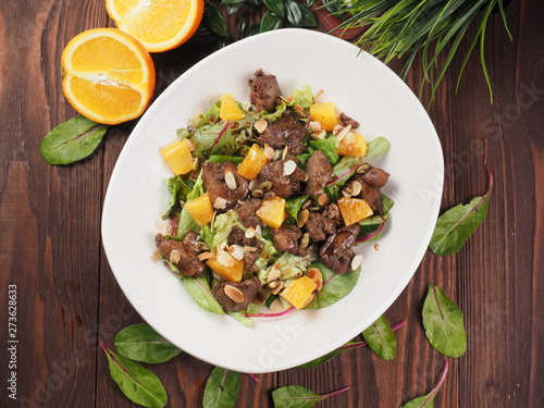 Fried meat with orange sauce on a white plate photo