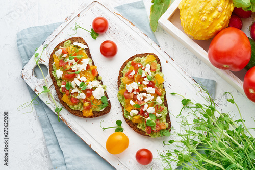 avocado toast with feta and tomatoes, smorrebrod with ricotta, top view