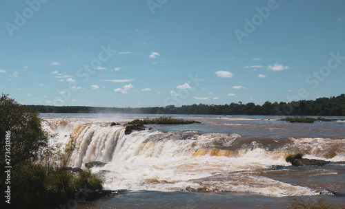 water flow behind the brown rocks in Iguazu Falls, Argentina