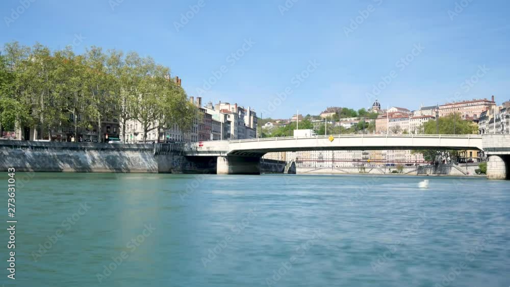 View on a bridge over the Saône in Lyon and on the banks of the river. Traffic on the bridge. Time lapse. Daylight, blue sky. Filmed in the spring. View on a bridge over the Saône in Lyon and on the banks of the river. Traffic on the bridge. Time lapse. Daylight, blue sky. Filmed in the spring.
