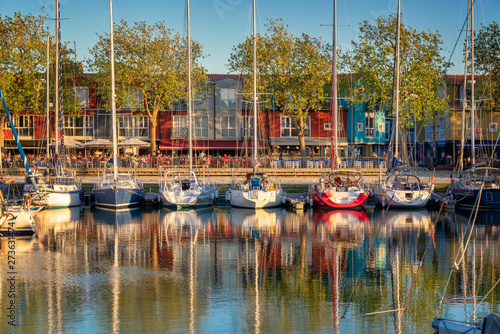 Sailboats and colorful houses of the Gabut district at sunset in the harbor of La Rochelle, France