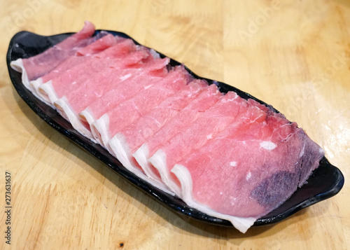 Shabu raw sliced pork on the tray. Close up the thin sliced pork for cooking meal.