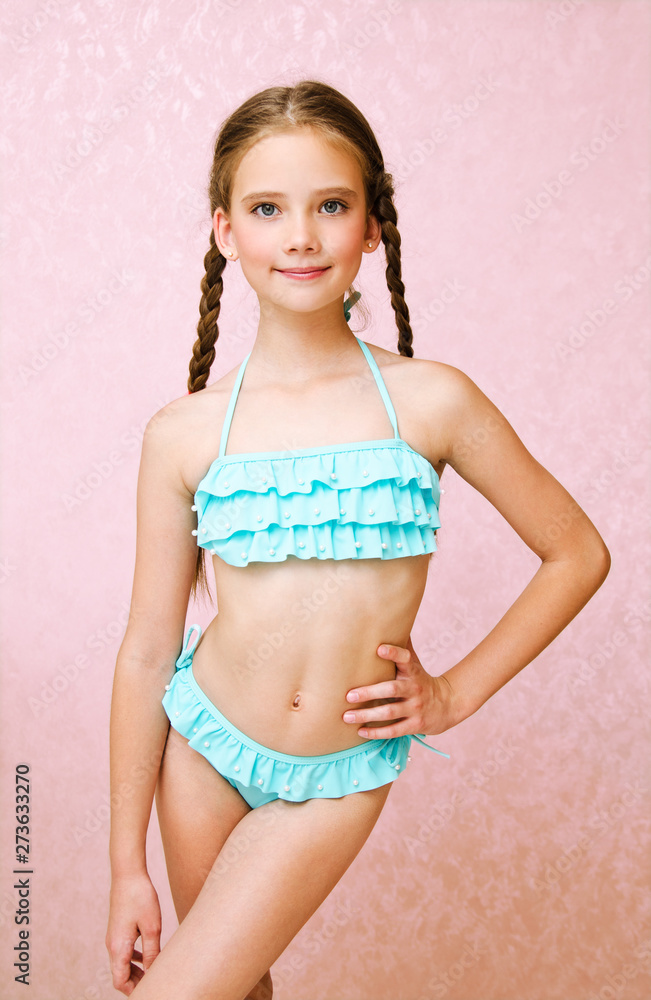 Portrait of cute smiling little girl child schoolgirl teenager in swimsuit isolated - obrazy, fototapety, plakaty 