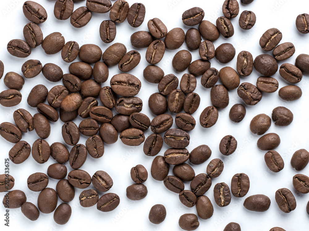 Obraz premium Coffee beans closeup on white background. Roasted coffee beans top view