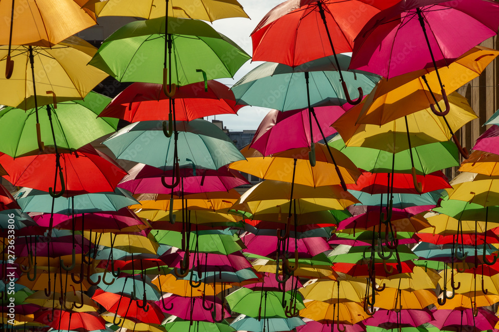 colorful umbrellas decorating the ceiling of a passage