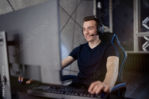 Fotografie, Obraz Professional gamer in his expensive studio young man having live stream playing online video game