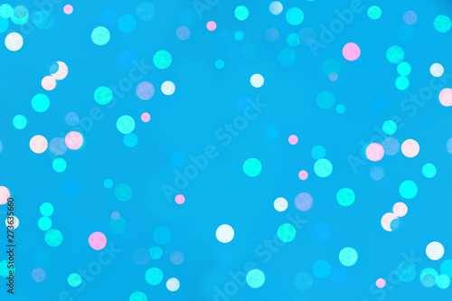 Colored confetti bokeh on blue background.