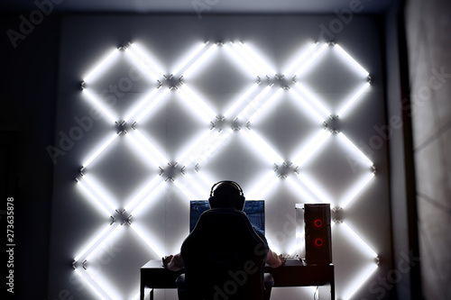 Professional gamer in his expensive studio young man having live stream playing online video game. Cyber sportsman is streaming popular pc computer game for his followers 