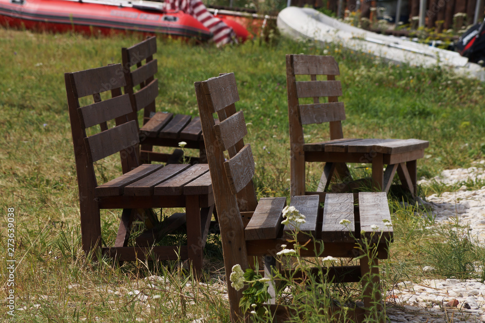 Wooden benches stand in the grass, summer landscape Wooden benches stand in the grass, summer landscape