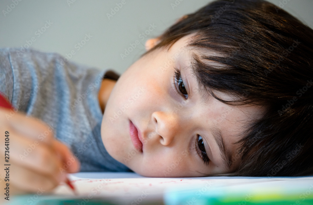 Selctive focus lonely child boy lying head down on table with sad face, Emotional portrait of Five years old kid bored with school homework, Spoiled child Selctive focus lonely child boy lying head down on table with sad face, Emotional portrait of Five years old kid bored with school homework, Spoiled child