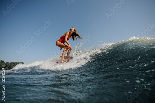 Woman with long hair surfs in sea
