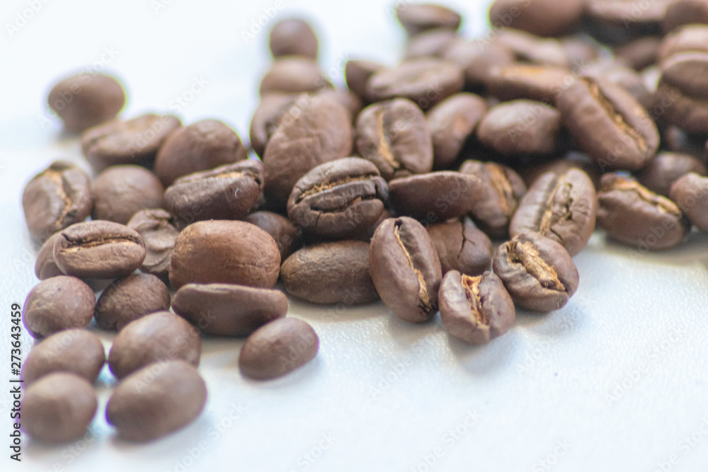 Naklejka premium Ganze Kaffeebohnen vor neutralem Hintergrund symbolisieren Kaffeegenuss für echte Kaffeeliebhaber