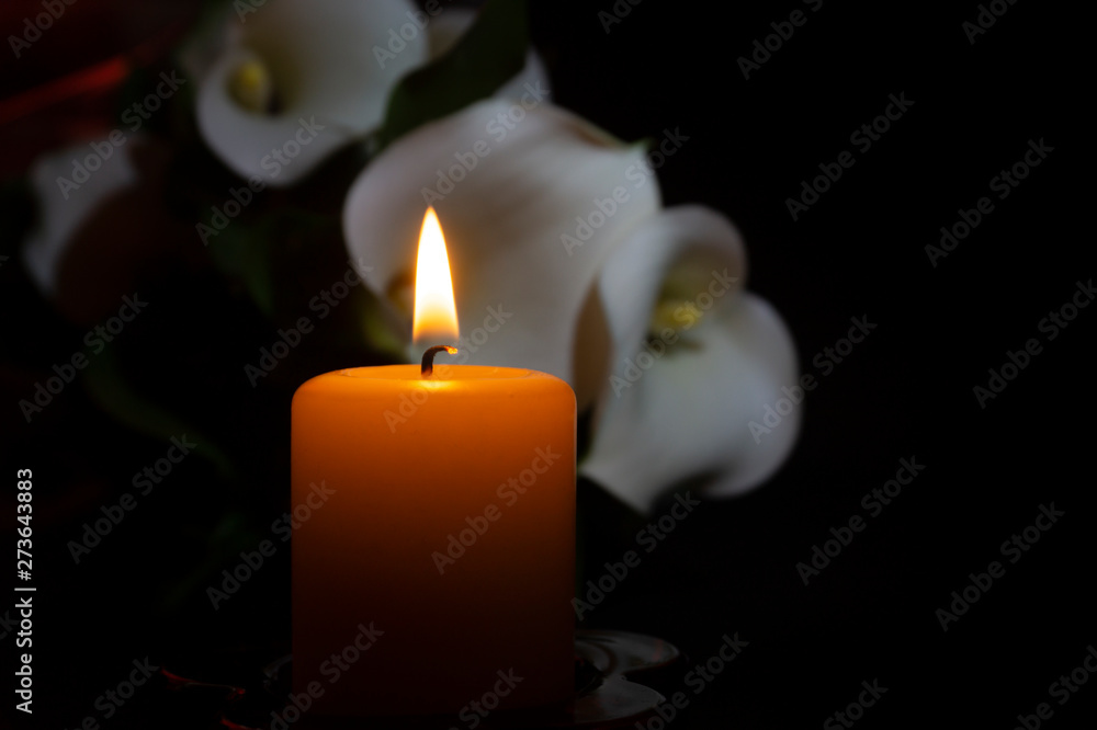 Close up of orange candle flame and lily flowers Close up of orange candle flame and lily flowers