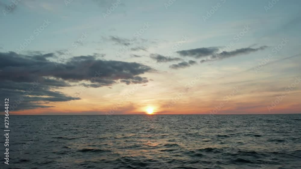 Golden sunset at Baltic sea with dramatic clouds. 4k aerial footage.