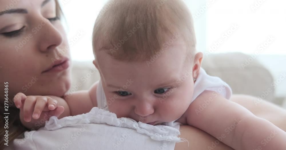 Happy mother relaxing with her tired baby daughter at home Happy mother relaxing with her tired baby daughter at home