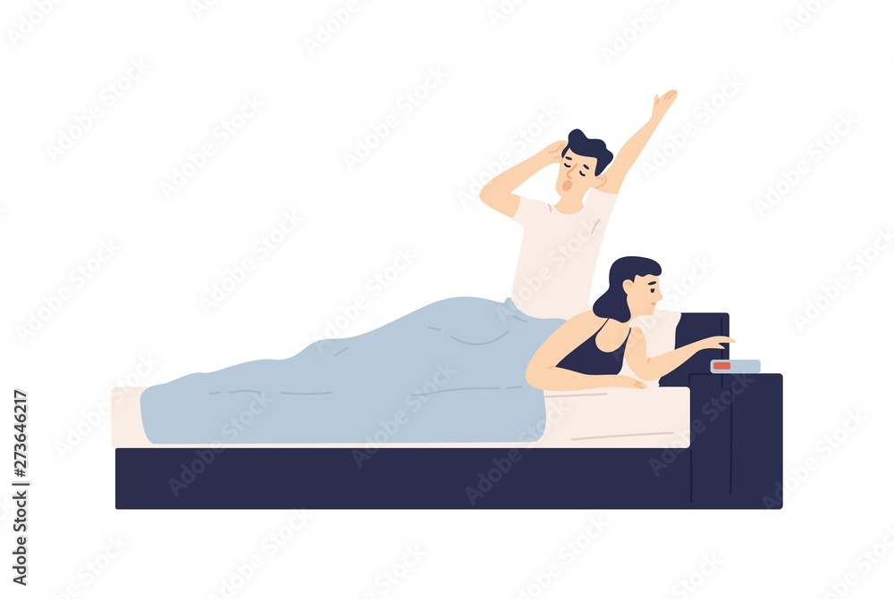 Man lying in bed, yawning and woman setting up alarm clock. Young couple  falling asleep or