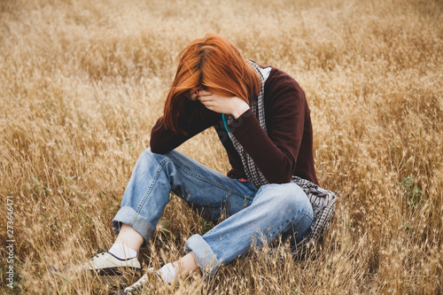 Lonely sad red-haired girl at field © Masson