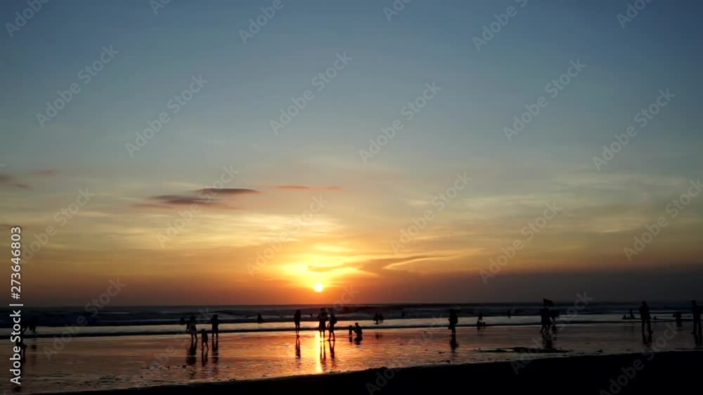 Ocean beach at sunset. Moving people (young and children and old), sand bay. Orange and blue sky with clouds. Timelapse Ocean beach at sunset. Moving people (young and children and old), sand bay. Orange and blue sky with clouds. Timelapse