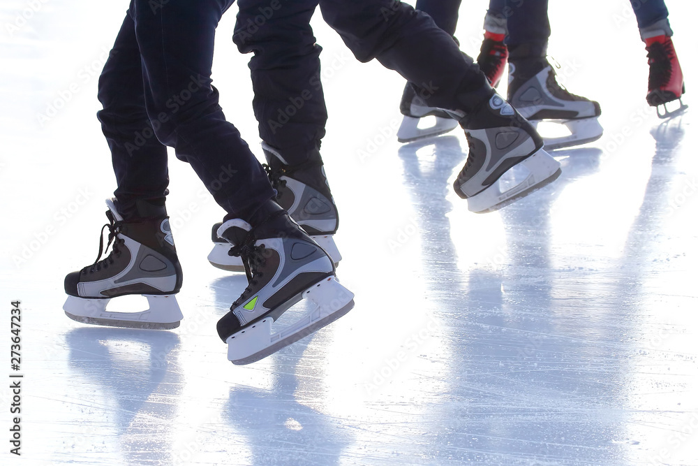 Obraz premium feet of different people skating on the ice rink