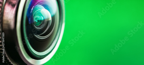  Banner. Camera lens and green backlight. Side view of the lens of camera on green background. Camera Lens Close Up. Optics