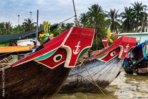 Canvas Print Boats with eyes and anchor painting decoration on the prow, anchored in the muddy waters of the Mekong Delta, Vietnam